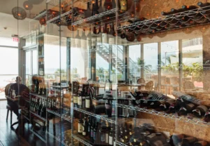 A stylish modern glass wine cellar showcasing a collection of wine bottles, serving as both storage and a design centerpiece.