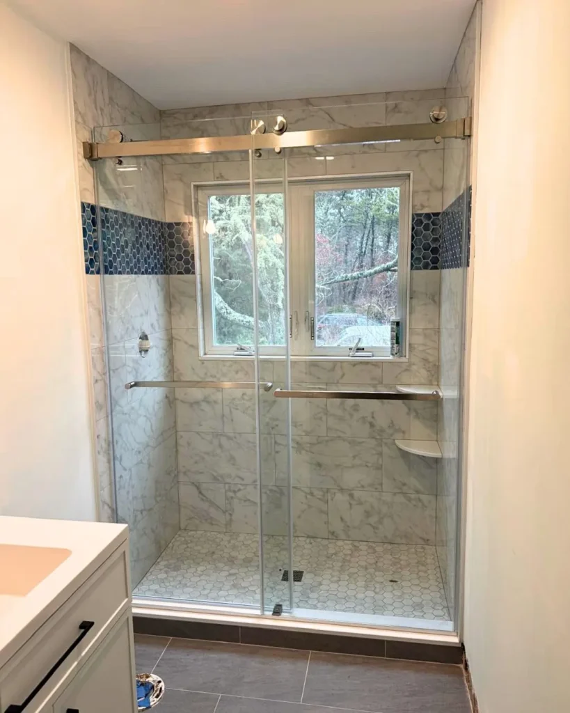 Custom glass shower doors with marble wall tile in Brewster MA