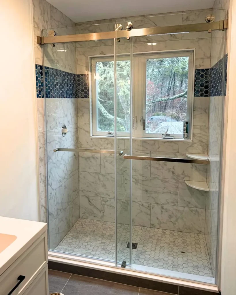 Sliding glass shower enclosure with brushed nickel roller hardware installed in Brewster MA
