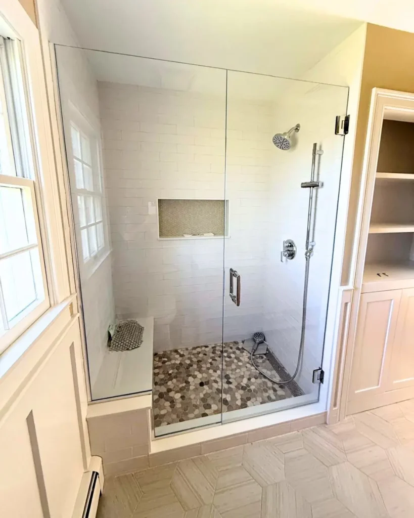 Glass shower door and panel fitted over built-in bench in Dennis MA