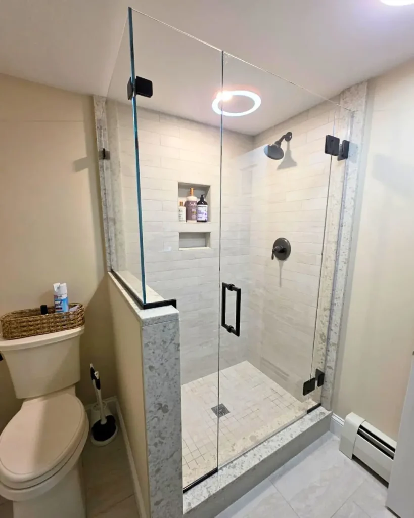 Frameless shower enclosure with matte black hardware installed in Centerville MA