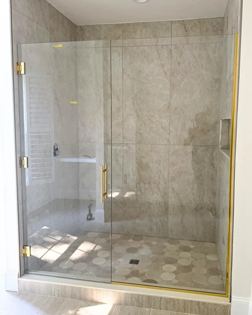 Brushed brass shower enclosure hardware detail in East Sandwich MA